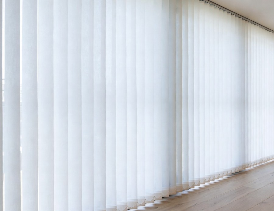 Sheer fabric vertical blinds across a wall of windows